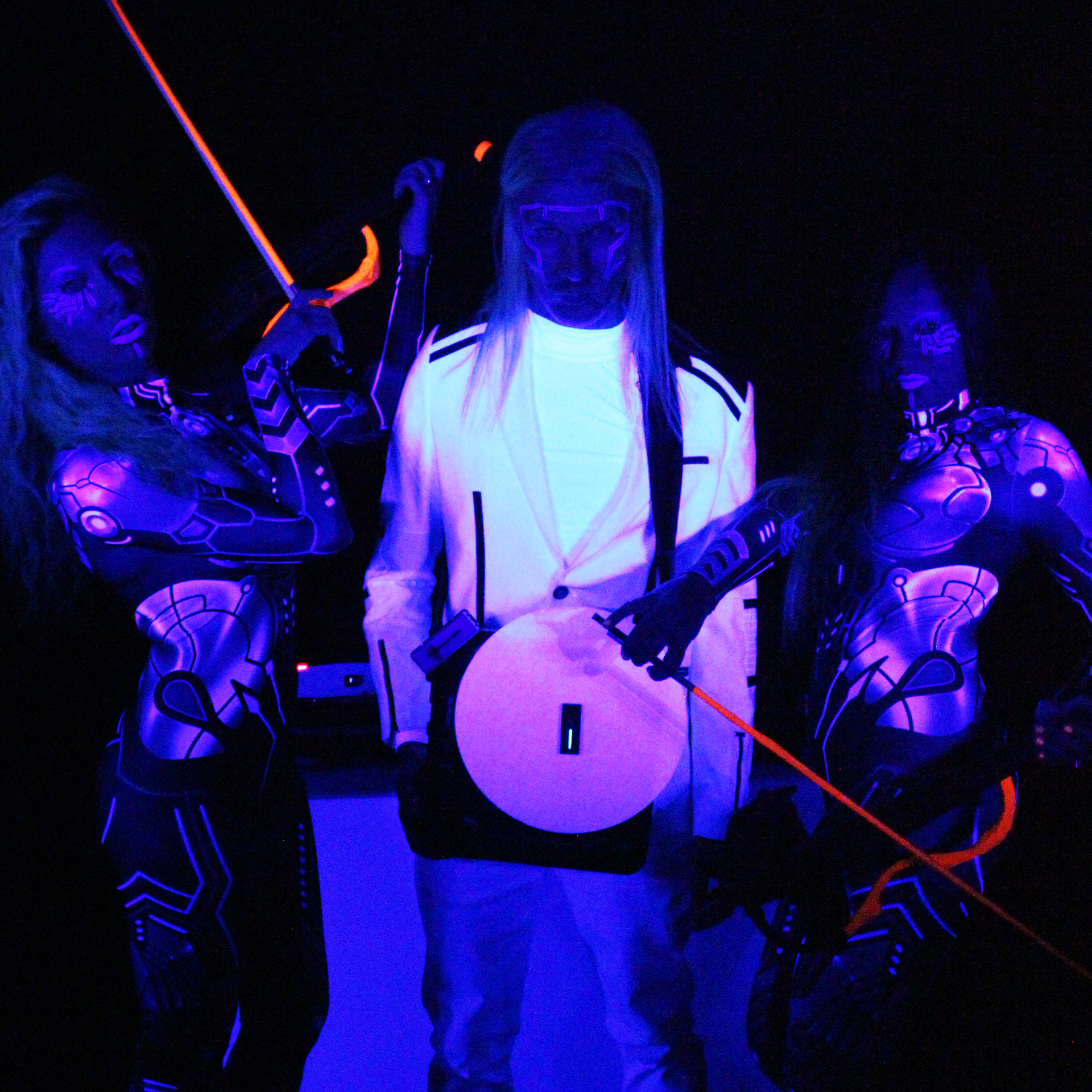 3 musicians lit UV Black Lights creating neon glow on their catsuits and corporate dress whites. dj holding portable turntable Violinists holding glow in the dark violins #vynilyn #lrbaggs #cordialcablesusa #codabow #thomastikinfeld #dollskillclothing #yamahaelectricviolin #justfabstyle #yamahamusic #electricviolin #electricviolinists #electricviolinist #aliens👽 #notfromthisworld #dancingviolinist #djculture #djviolinist #djviolin #femaleartist #femalemusicians #longhairedman #followusonyoutube #vinylart #bookmorewomen #eventplanner #eventplanning #eventprofs #meetingprofs #corporateeventplanner #meetingplanner #corporateevent #zoomhappyhour #virtualevents 