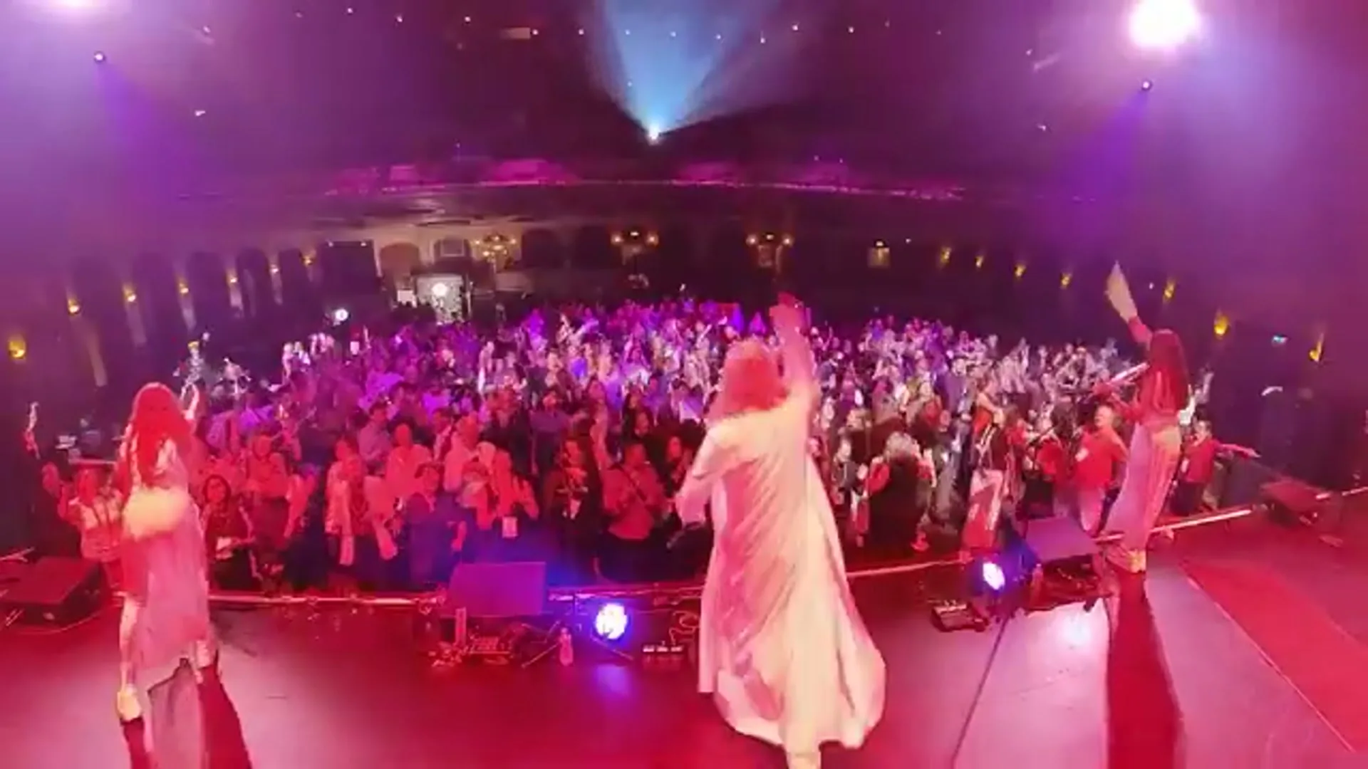 A VYNILYN DJ and violin show performing to a sold-out theatre crowd under pink and purple stage lighting